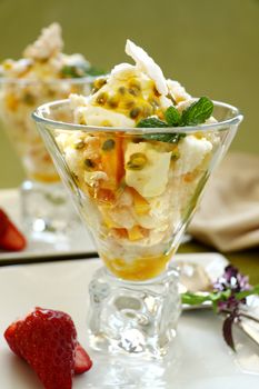 Delicious meringue dessert with pawpaw and passionfruit sauce with strawberries.
