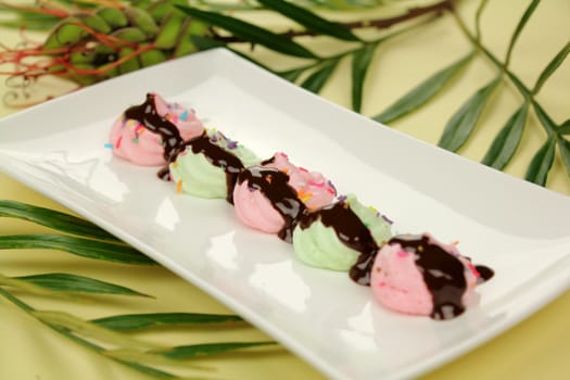 A line of chocolate mini meringues on a plate ready to serve.