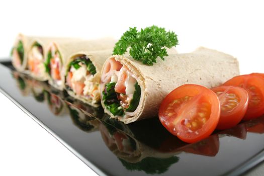 Mixed platter of delicious ham and chicken salad wraps.
