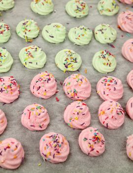 Colorful meringues on baking paper straight out of the oven.
