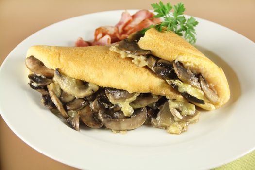 Delicious sliced mushroom omelette with cheese, bacon and parsley ready to serve for breakfast.