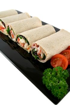 Mixed platter of delicious ham and chicken salad wraps.