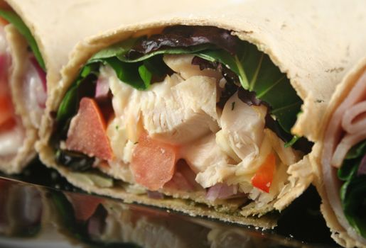 Mixed platter of delicious ham and chicken salad wraps.