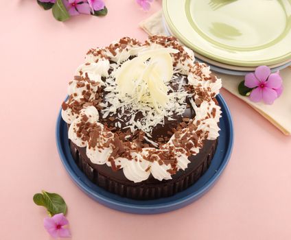 Deicious rich chocolate mud cake with white chocolate garnish sculpture.