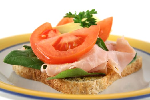 Ham, lettuce, tomato and cheese open sandwich on wholemeal bread.  