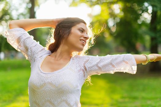 Beauty portrait of an attractive multi-ethnic girl enjoying the warmth of a summer sunset. Sun Flare serie