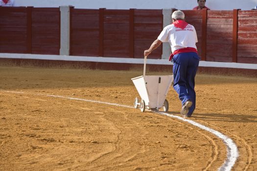 employee of the Bullring painting with a machine the white line of the bullring, Pozoblanco, Cordoba province, Andalusia, Spain