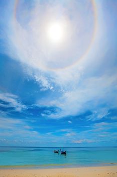 Halo around the sun over boats in the water on Koh Lipe