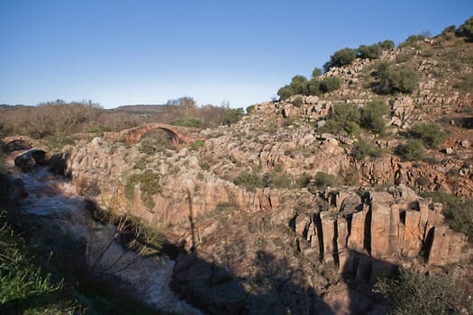 It is a Roman bridge that could belong to the primitive via Herculea, linking the ancient Oretania with the Spanish Levant, 3rd century a. d. C. Is the landscape a beautiful formation of granitic rocks that are precipitating the River Guarrizas, forming two spectacular waterfalls that save the unevenness caused by the failure of Linares.