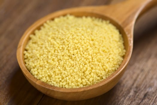 Raw couscous on wooden spoon (Very Shallow Depth of Field, Focus one third into the couscous)