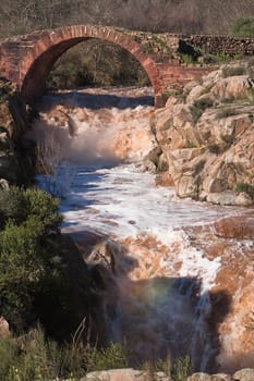 It is a Roman bridge that could belong to the primitive via Herculea, linking the ancient Oretania with the Spanish Levant, 3rd century a. d. C.. Is the landscape a beautiful formation of granitic rocks that are precipitating the River Guarrizas, forming two spectacular waterfalls that save the unevenness caused by the failure of Linares.