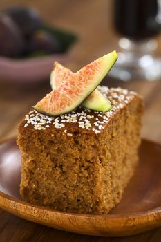 Fresh fig cake with fig wedges on top served on wooden plate (Selective Focus, Focus on the front of the fig wedge)