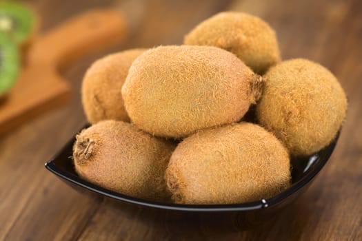 Kiwi fruits in black bowl (Selective Focus, Focus on the kiwi on the top)