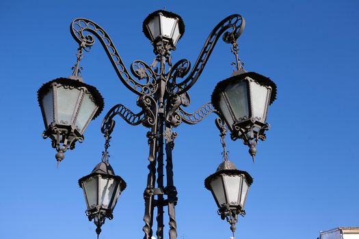 A wrought iron lamp on a weathered wall in First of May Square, Ubeda, province of Jaen, Spain