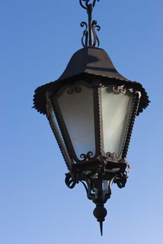 A wrought iron lamp on a weathered wall in Spain