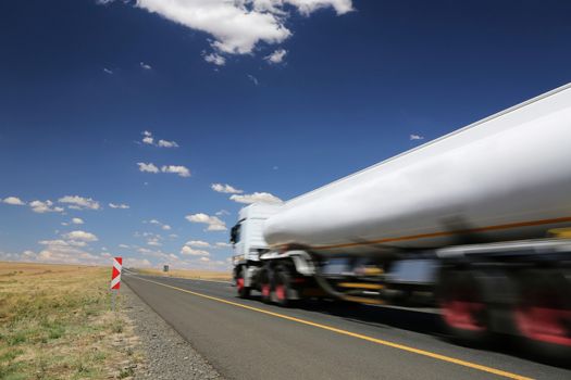 White tanker truck transporting fuel along the tar highway