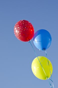 three colorful balloons on blue summer sky. Holiday background
