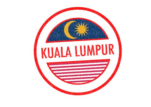 Passport-style KUALA LUMPUR rubber stamp over a white background.