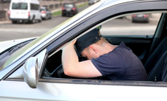 Tired Man fall asleep in a Car at the City Crossroad