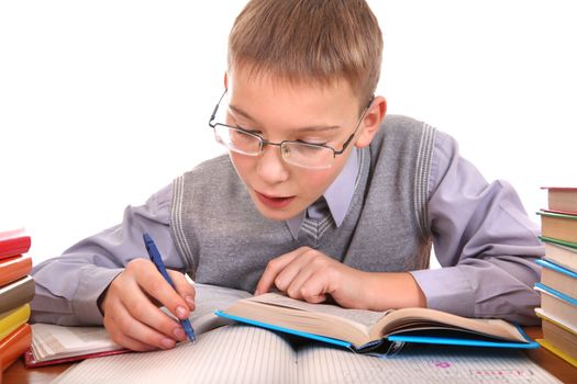 Schoolboy writing at the School Desk on the white background