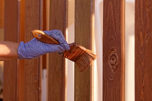 planks fence dyeing with brown paint and brush