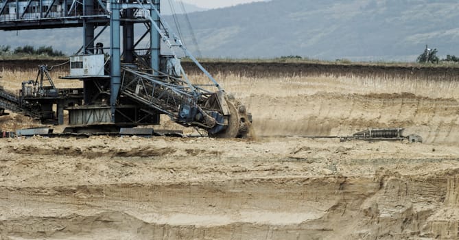 Coal mining in an open pit with huge industrial machine