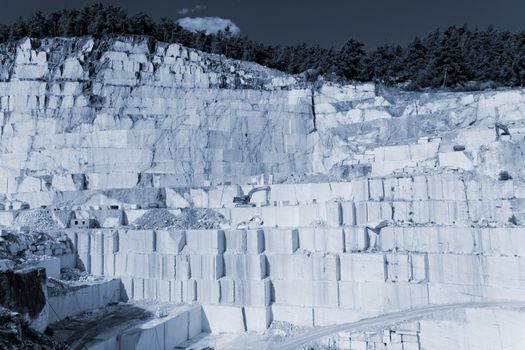 Detail of huge Thassos white marble quarry (mine) with grabber (color filtered photo) abstract