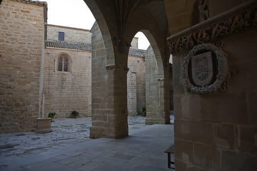 Cloister of Church of Santa Maria de los Reales Alcazares and shield on the stone wall, Ubeda, Jaen province, Spain