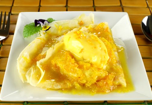 Delicious orange crepes with citrus ice cream and custard creme.