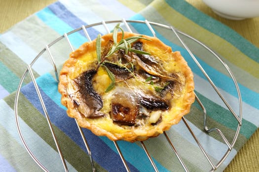 Mushroom quiche on a baking rack straight from the oven.