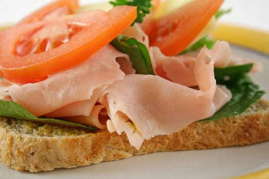 Ham, lettuce, tomato and cheese open sandwich on wholemeal bread.  