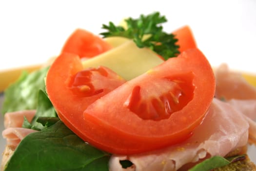 Tomato, ham, lettuce and cheese open sandwich on wholemeal bread.  