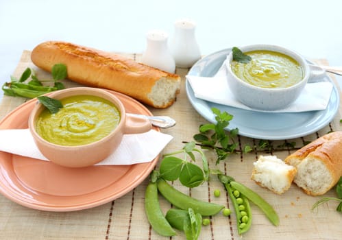 Delicious bowls of pea soup with fresh mint and crusty bread.