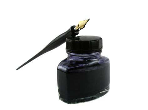 Vintage pen lying on top of a bottle of ink.