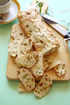 Fresh baked sweet pistachio bread sliced on a bread board ready to serve.