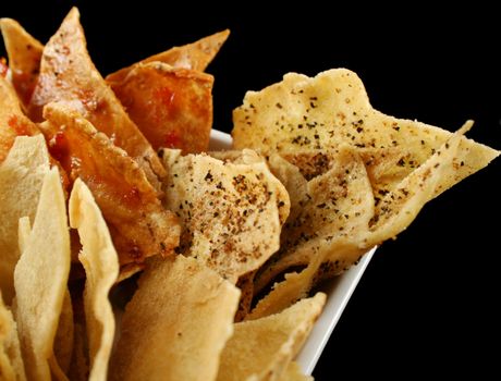 Bowl of home style assorted baked pita crisps with herbs.