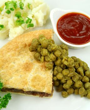 Meat pie with mushy peas and mashed potato and ketchup.