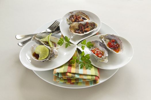 Platter of oysters including oysters kilpatrick, with sweet chilli and with lime and soy sauce.