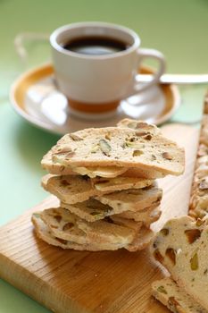 Fresh baked sweet pistachio bread sliced on a bread board with coffee.