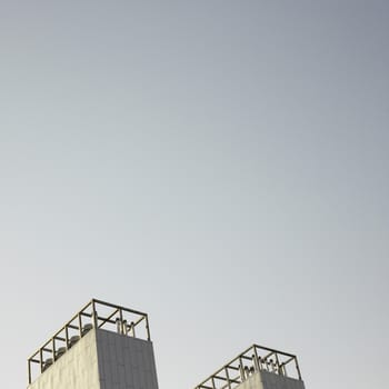 Modern smokestack twin building with dark sky