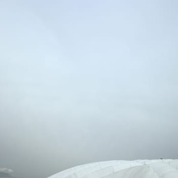 Inflated white roof stadium against cloudy sky