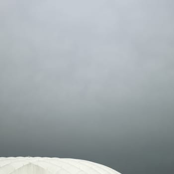 Inflated white roof stadium against cloudy sky