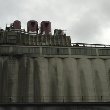Large dark factory against grey sky