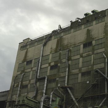 Large dark factory against grey sky