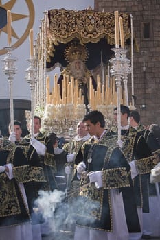 Young people in procession with incense burners and processional candlesticks in Holy week, Linares, Jaen province, Spain