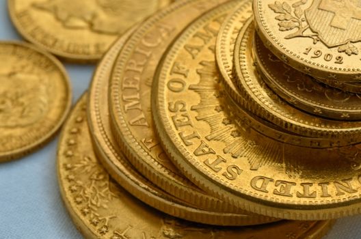 Few old golden coins, swiss francs, American liberty twenty dollars, russian rubels. Still life.