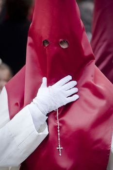 Penitent with a rosary in his hand in a procession, Spain