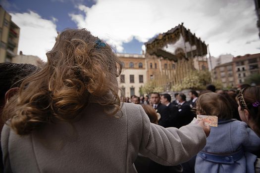 Blonde girl with a postcard of the Virgin Mary in Holy week, Spain