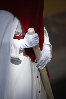 Detail penitent white holding a candle during Holy Week, Spain