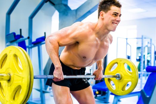 bodybuilder with barbell in gym